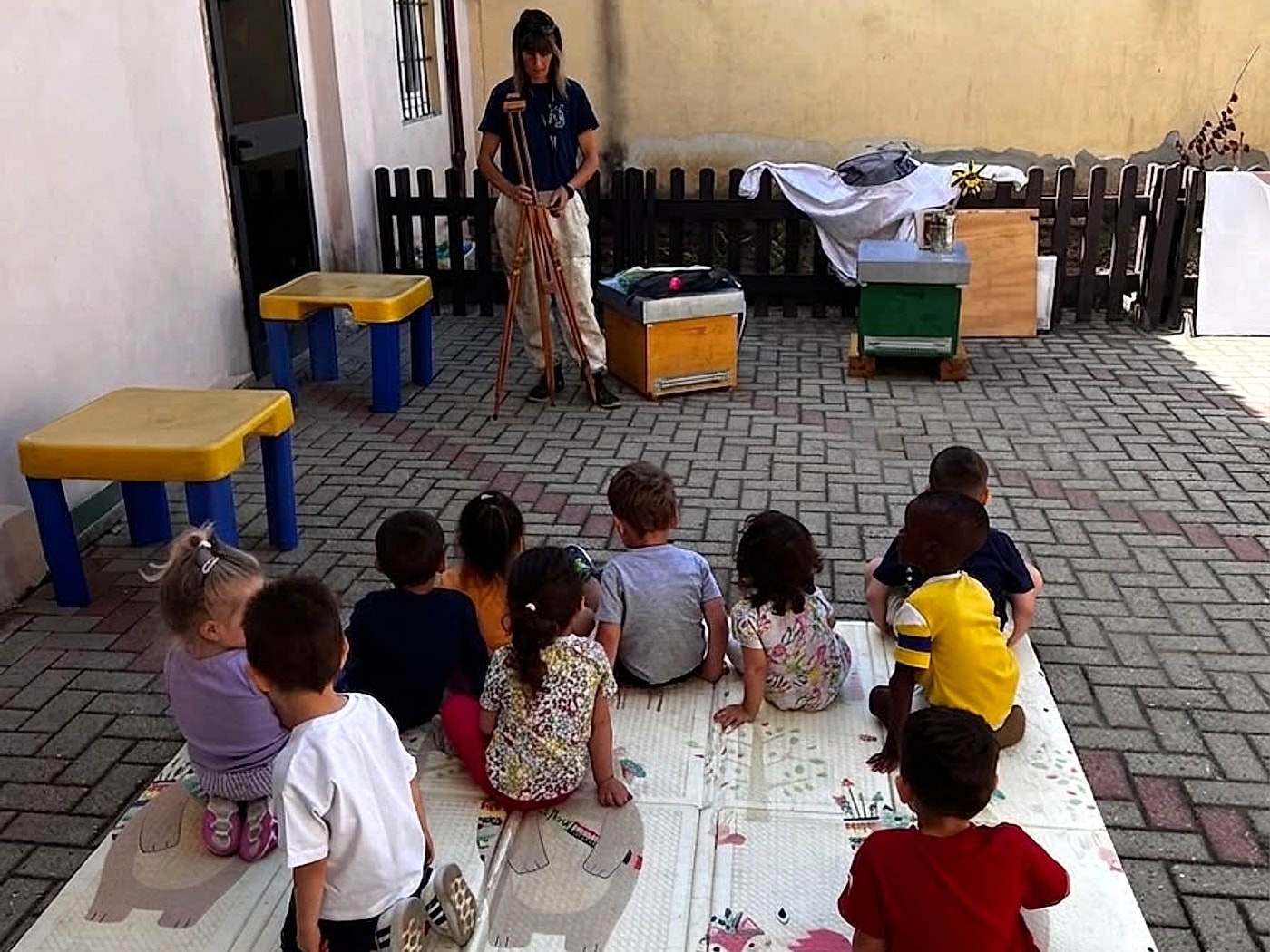 Gruppo di bambini seduti in cerchio durante il laboratorio didattico sulle api